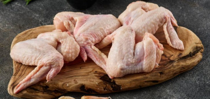 Raw chicken wings Poultry meat with spices, salt and pepper, on gray background. Close up.
